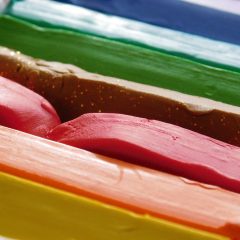 Close-up of stacked bars of modelling clay in green, brown, red, pink and yellow