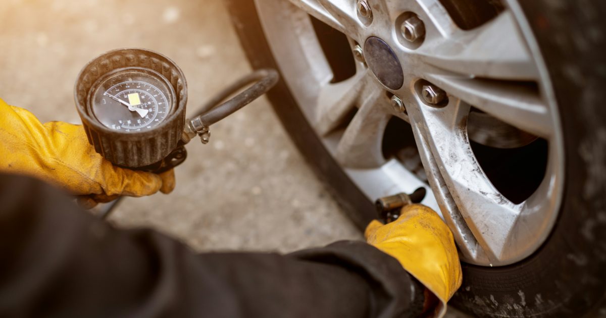 A tire inflator with a dial gauge on a car tire