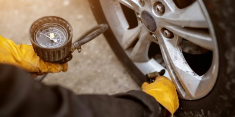 A tire inflator with a dial gauge on a car tire