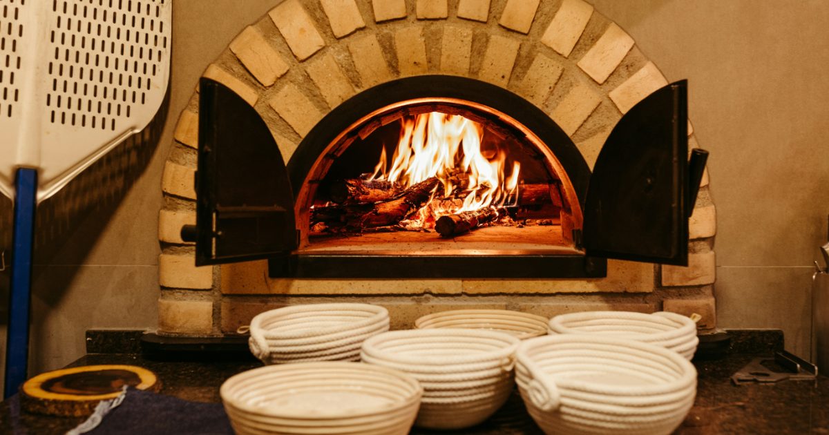 A wood-fired pizza oven with a fire burning inside