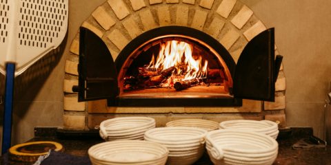 A wood-fired pizza oven with a fire burning inside