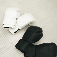 Black and white boxing gloves on a pale floor
