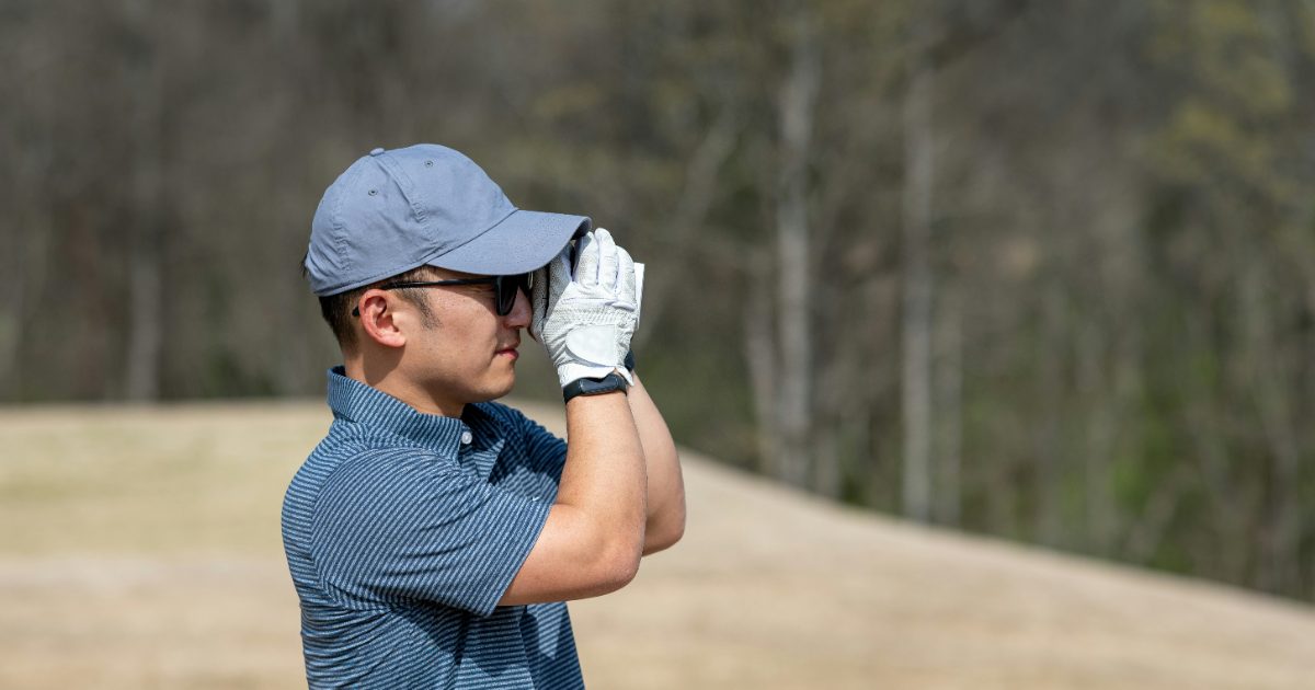 A golfer checking the distance with a rangefinder