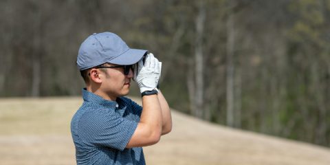 A golfer checking the distance with a rangefinder