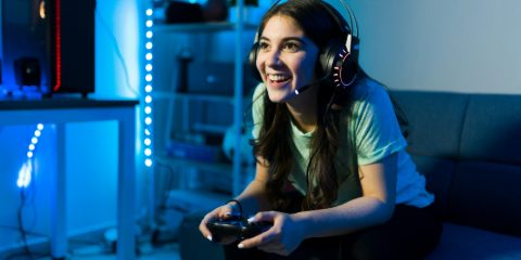 A smiling young woman gaming in a headset