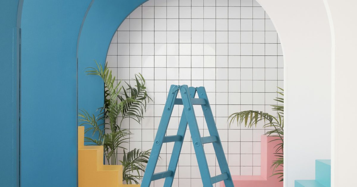 A blue step ladder in a bright room with arches, tiles and plants
