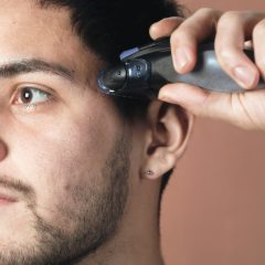 A man tidying up by his ear with a small trimmer