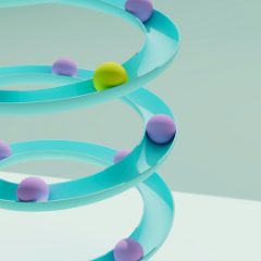 Marbles rolling down a turquoise spiral track