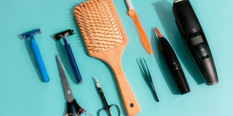 Grooming tools including a nose hair trimmer on turquoise