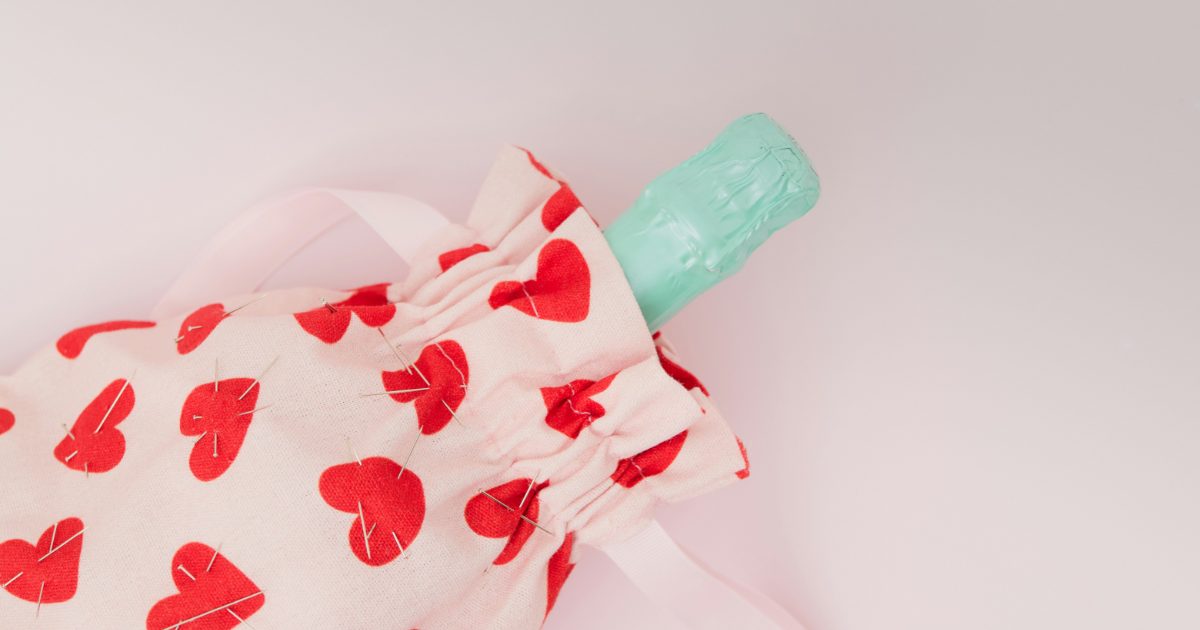 A hot water bottle in a heart-print cover