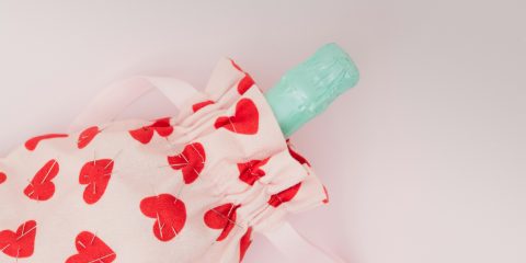 A hot water bottle in a heart-print cover