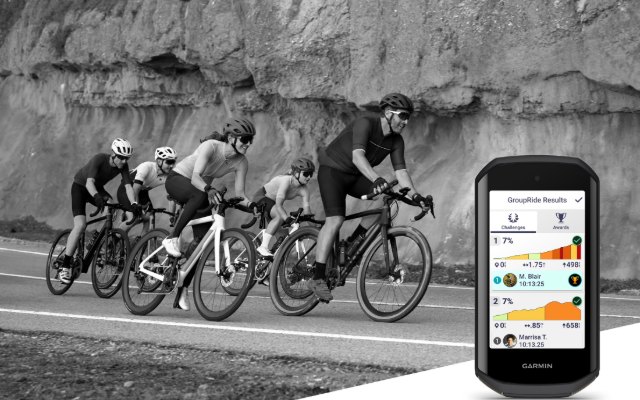 A Garmin Edge 1050 with a group of road cyclists riding along a cliff road behind it