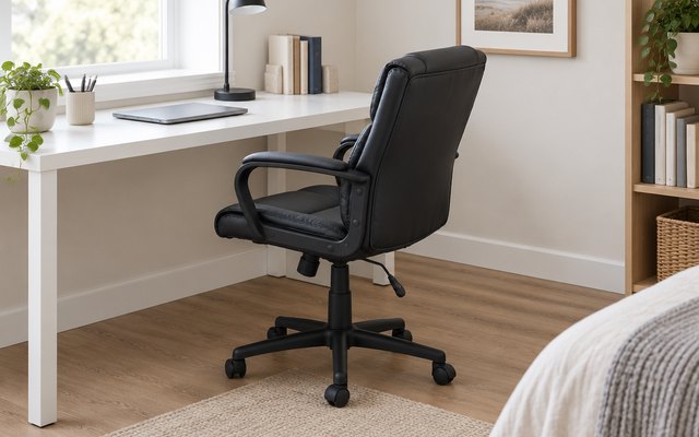 Mid-back faux leather office task chair, at a white desk in a spare bedroom office