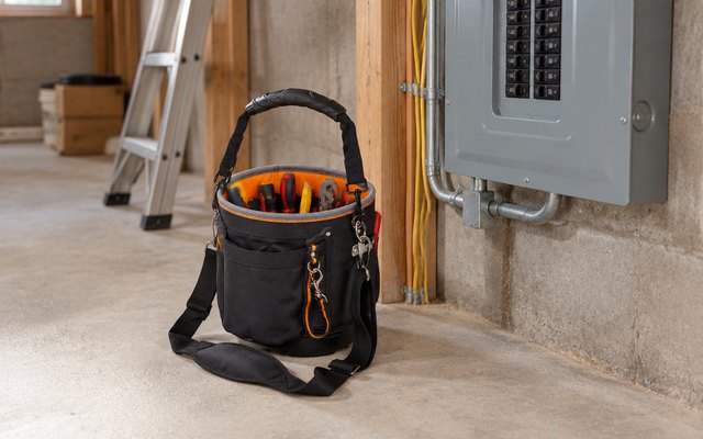 Klein Tools Tradesman Pro tool bag, on the floor of an unfinished basement beside an electrical panel