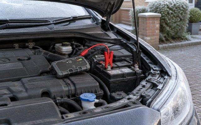 NOCO Boost GB40 jump starter, clamped to a car battery on a frosty driveway