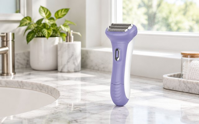 Remington Smooth & Silky shaver, standing on a marble vanity by a window in a bright bathroom