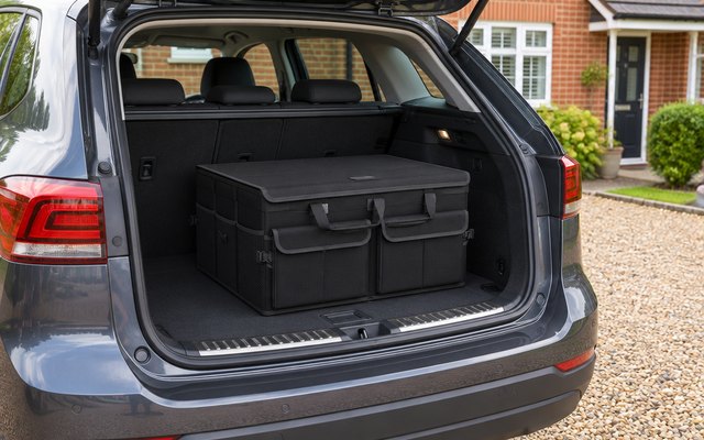 FORTEM boot organiser, sitting with its lid closed in the open boot of a family hatchback parked on a gravel driveway outside a red-brick semi-detached house