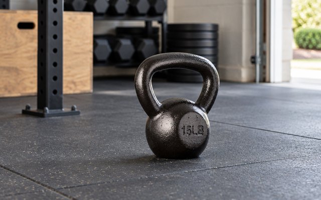 Amazon Basics cast iron kettlebell, on a rubber mat in a garage home gym