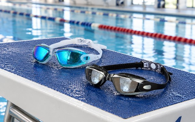 ALLPAIPAI Swim Goggles, on the starting block of an indoor pool lane