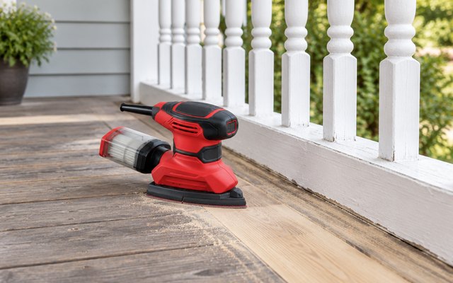SKIL 4-in-1 multi-sander, on a wooden porch floor beside a white-painted spindle railing being sanded