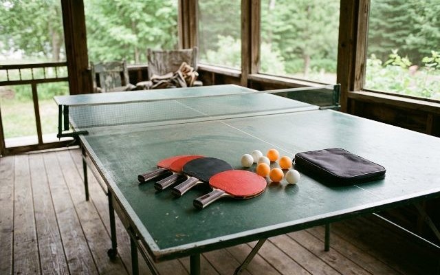 Four-paddle ping pong set, on a table tennis table on a cottage porch