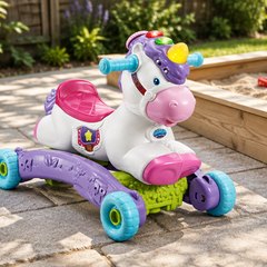 VTech Prance and Rock Learning Unicorn, on a paved patio beside a sandbox