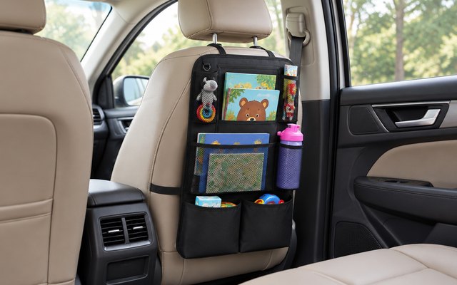 Helteko backseat organizer, strapped to the back of a front seat in a family SUV, seen from the back seat, holding a few picture books and a water bottle