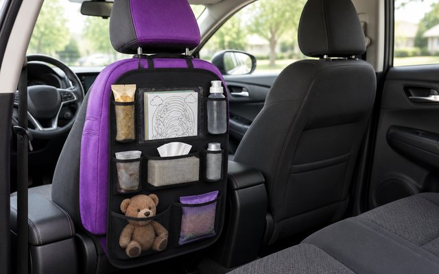 ONE PIX backseat organizer, strapped to the back of the driver's seat in a left-hand-drive hatchback, holding a coloring book, snacks and a teddy bear