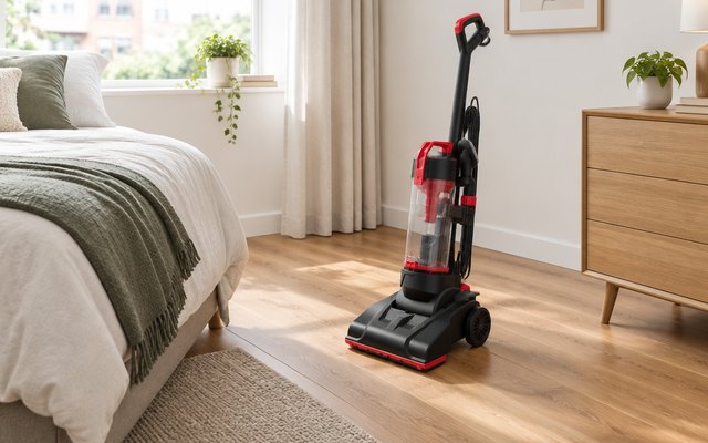 Bissell CleanView Compact vacuum, standing on the wood floor of a small apartment bedroom