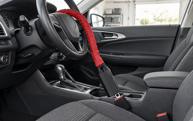 KAYCENTOP steering wheel lock, its red cable looped around the wheel and clipped into the driver's seat-belt buckle in a parked sedan