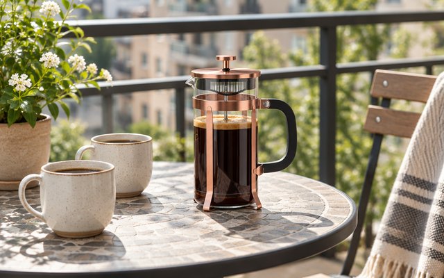 QUQIYSO glass French press, on a small round bistro table on a sunny apartment balcony beside two cups