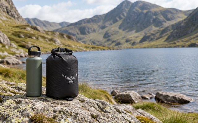 Osprey Ultralight Dry Sack, on a rock beside a mountain lake in Snowdonia, a flask beside it