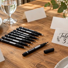 PANDAFLY lettering pens, on a wooden dining table beside blank place cards for a dinner party
