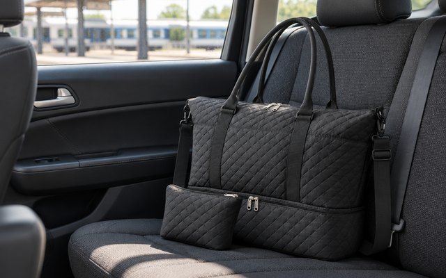 HOTOR Travel Duffel Bag with Shoe Compartment, on the back seat of a car at a train station