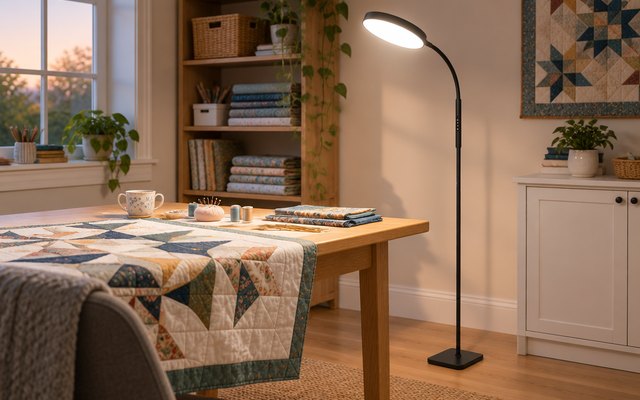 PACOVY LED floor lamp, angled over a craft table with a half-finished quilt in a bright hobby room
