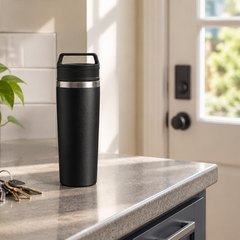 Stanley Café-To-Go mug, on a kitchen counter by the back door beside a set of keys